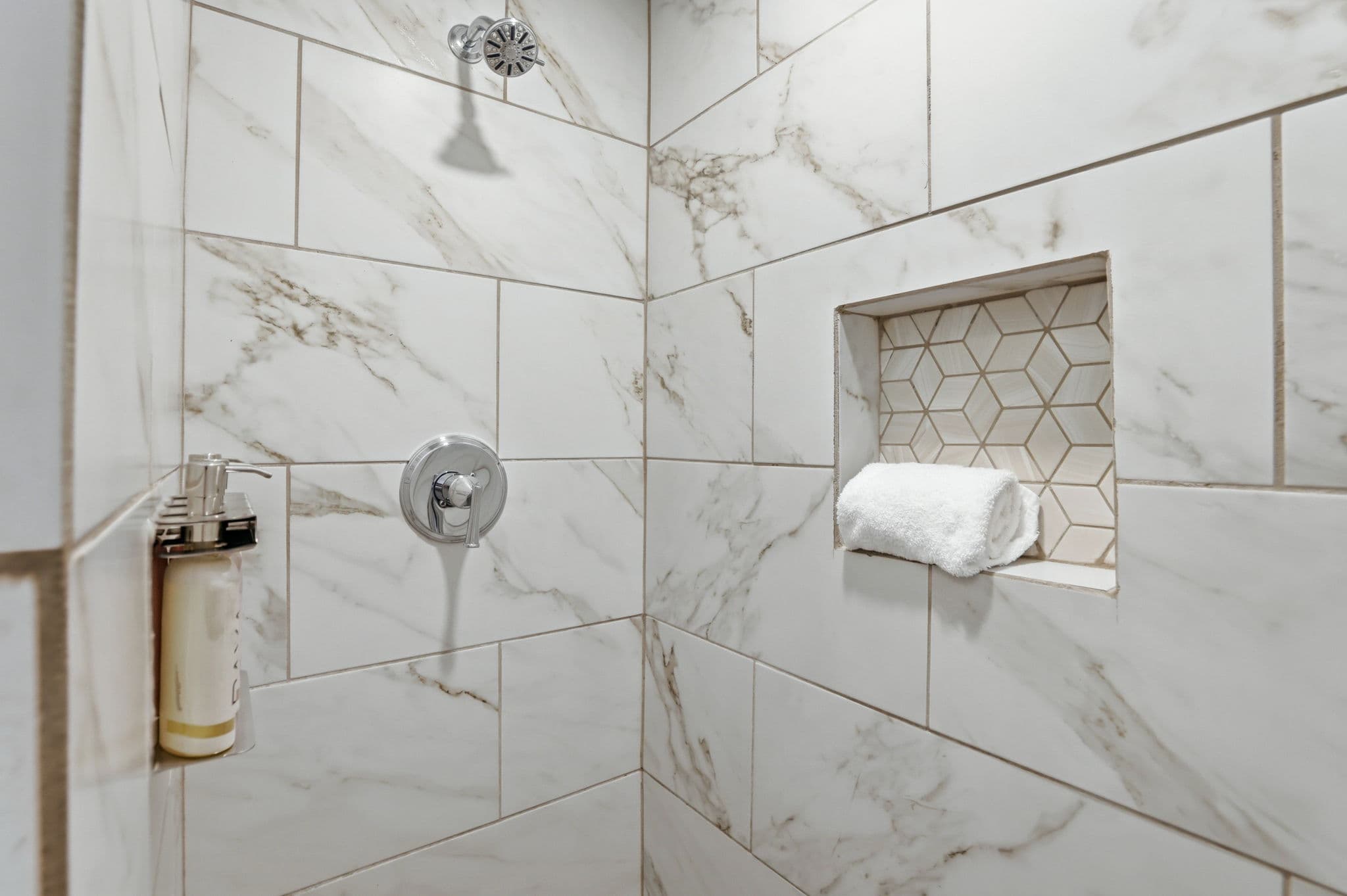 Marble shower with a folded towel niche in a short term rental in North Little Rock, Arkansas
