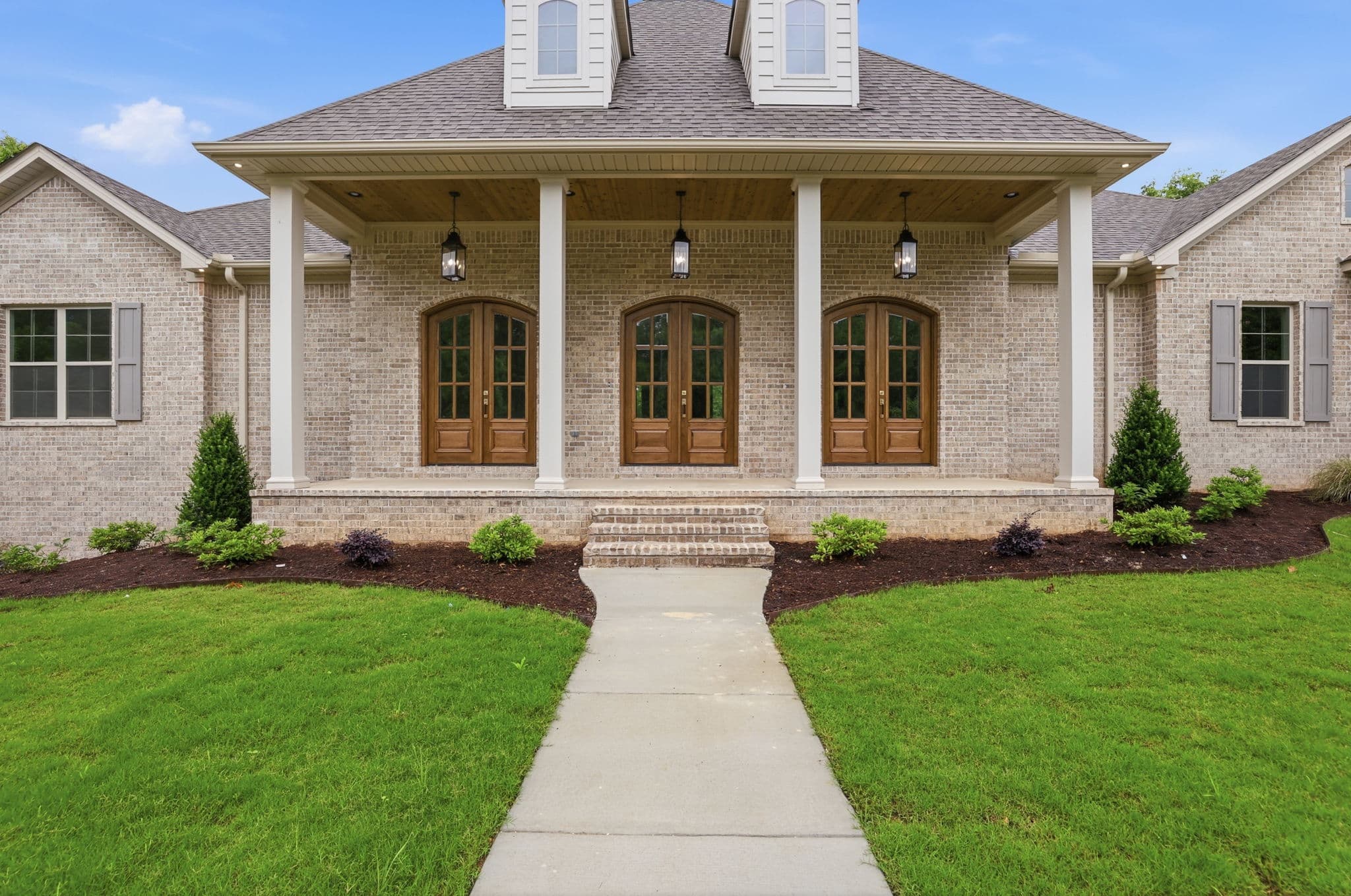 Acadian brick front elevation with dormers on a new construction home in Benton, Arkansas