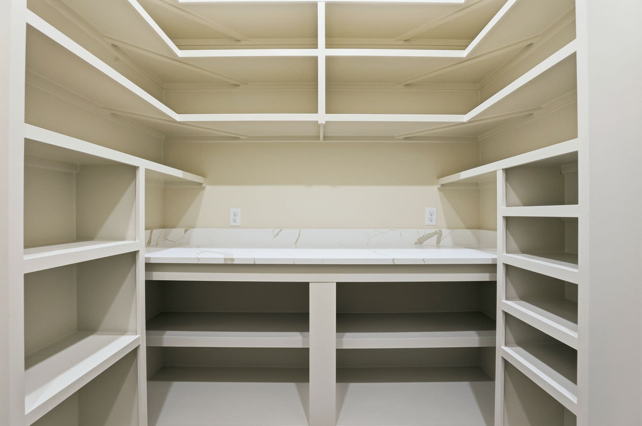 Walk in pantry with white shelving and a stone counter in a new construction home in Benton, Arkansas