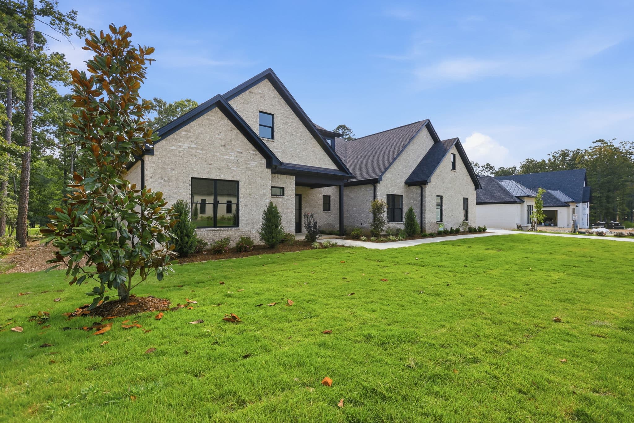 Modern white brick front elevation with black windows on a new construction home in Little Rock, Arkansas