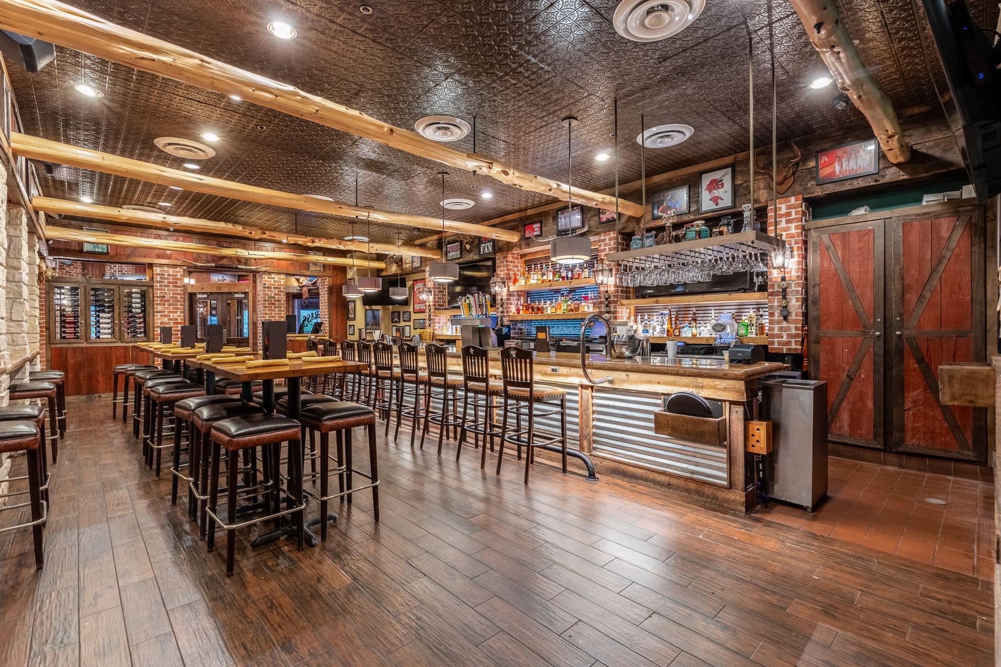 Restaurant bar with a pressed tin ceiling and warm lighting at 10 Anglers Way in Little Rock, Arkansas