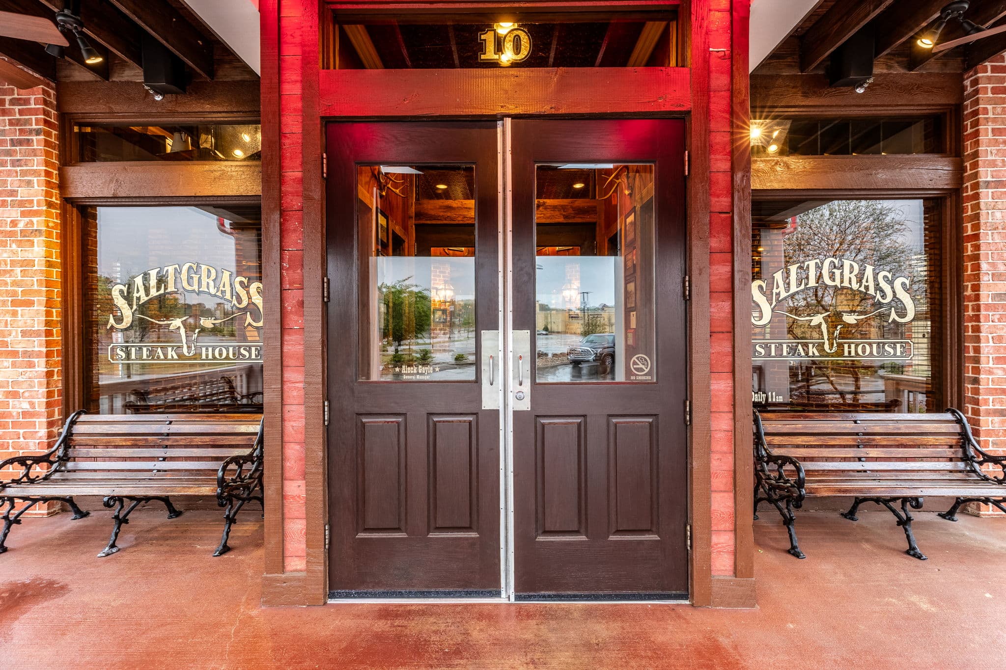 Covered entry with wood double doors and steakhouse signage etched on the glass at 10 Anglers Way in Little Rock, Arkansas