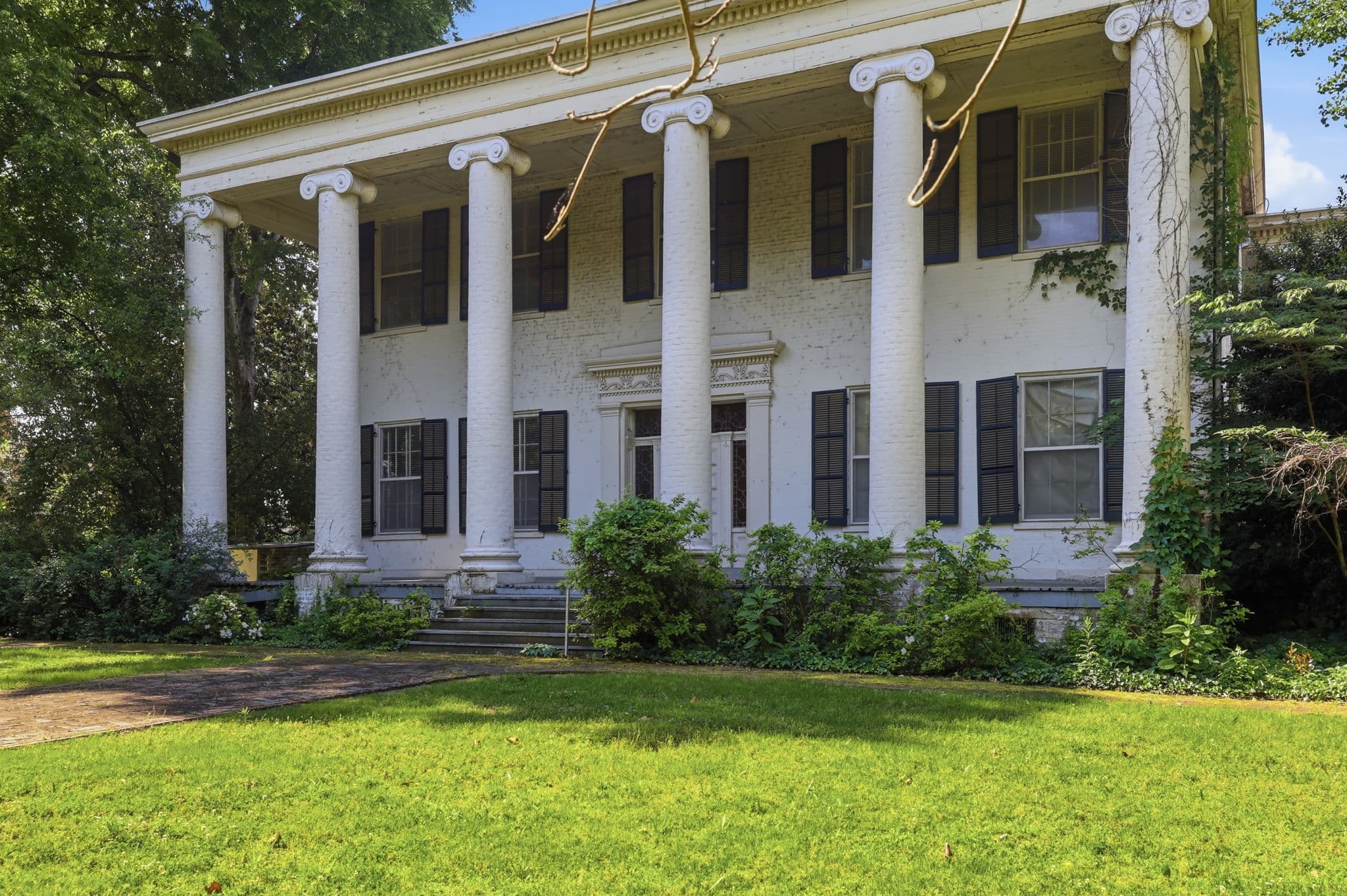 Columned portico and front lawn of a Greek Revival mansion at 411 7th Street in Little Rock, Arkansas
